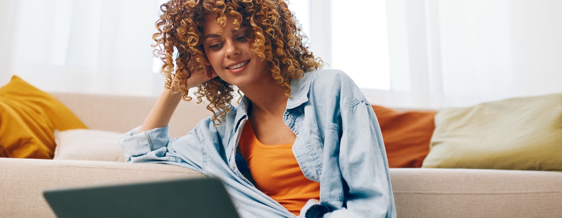 a person sitting on the ground looking at a laptop